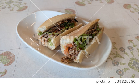 Vietnamese pork sandwich with coriander and carrot on a white plate  139829380