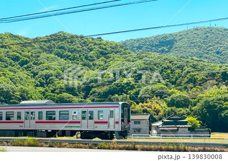 青空と新緑の山を背景に走る日本の電車 139830008