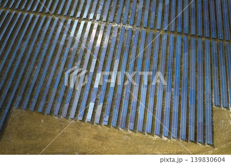 Aerial view of big sustainable electric power plant with many rows of solar photovoltaic panels for producing clean electrical energy. Renewable electricity with zero emission concept Aerial view of big sustainable electric power plant with many rows of solar photovoltaic panels for producing clean electrical energy. Renewable electricity with zero emission concept 139830604