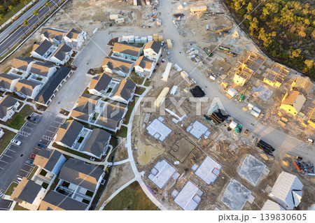 Aerial view of unfinished wooden frames of affordable houses under construction. Development of residential housing in American suburbs. Real estate market in the USA Aerial view of unfinished wooden frames of affordable houses under construction. Development of residential housing in American suburbs. Real estate market in the USA 139830605