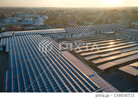 Aerial view of blue photovoltaic solar panels mounted on industrial building roof for producing green ecological electricity. Production of sustainable energy concept 139830715