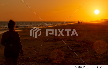 Long shot of a woman silhouette at the sunset beach Long shot of a woman silhouette at the sunset beach 139831289