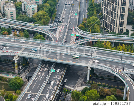 Multilevel highway interchange with numerous vehicles traversing elevated roads and ramps in a dense city environment Multilevel highway interchange with numerous vehicles traversing elevated roads and ramps in a dense city environment 139831787