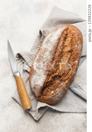 Homemade sourdough rye bread with knife on linen Homemade sourdough rye bread with knife on linen 139832226