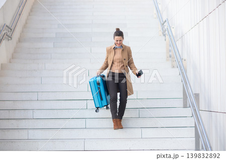 Woman with Blue Suitcase Descending Station Stairs Woman with Blue Suitcase Descending Station Stairs 139832892