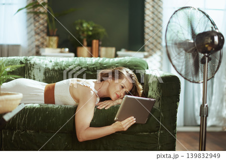 Content Woman Enjoying Tablet on Velvet Sofa Content Woman Enjoying Tablet on Velvet Sofa 139832949
