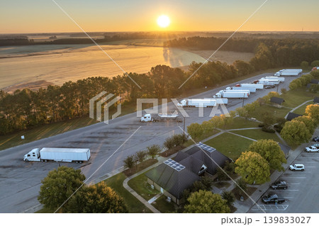 Large truck stop with resting area near busy American interstate freeway. Parking place during big rig interstate travel Large truck stop with resting area near busy American interstate freeway. Parking place during big rig interstate travel 139833027