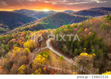 Car driving along mountain road surrounded by colorful autumn trees in Tennessee. Scenic road trip through the Appalachians in fall season Car driving along mountain road surrounded by colorful autumn trees in Tennessee. Scenic road trip through the Appalachians in fall season 139833116