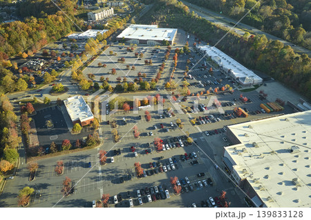 View from above of american grocery store with many parked cars on parking lot with lines and markings for parking places and directions. Place for vehicles in front of a strip mall center View from above of american grocery store with many parked cars on parking lot with lines and markings for parking places and directions. Place for vehicles in front of a strip mall center 139833128