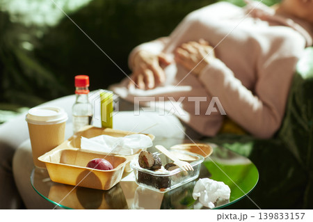 Overeating Consequences - Woman Resting with Stomach Pain Overeating Consequences - Woman Resting with Stomach Pain 139833157