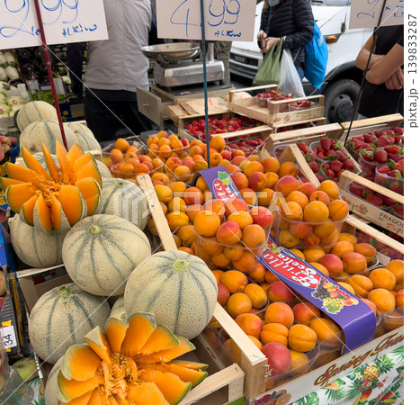 A vibrant market stall filled with fresh fruits including apricots, melons, strawberries. 139833287