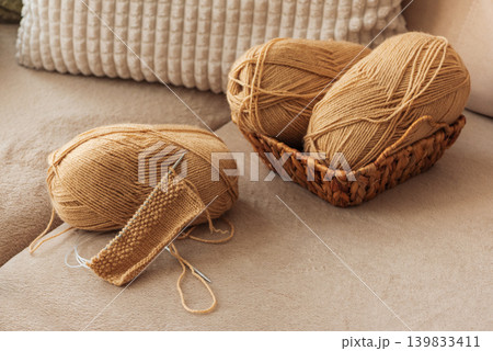 Closeup Knitting Setup with Yarn Basket and Cozy Sofa Closeup Knitting Setup with Yarn Basket and Cozy Sofa 139833411