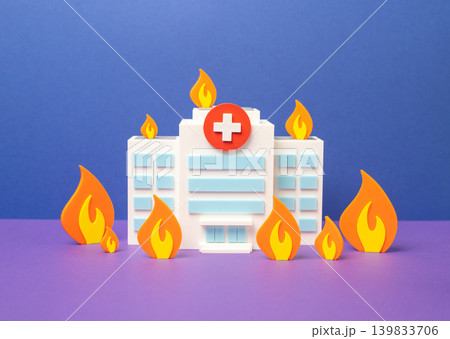 The hospital is engulfed in flames. The concept of overloading a medical facility. The healthcare system is at its limits and budget cuts increase pressure. The hospital is engulfed in flames. The concept of overloading a medical facility. The healthcare system is at its limits and budget cuts increase pressure. 139833706