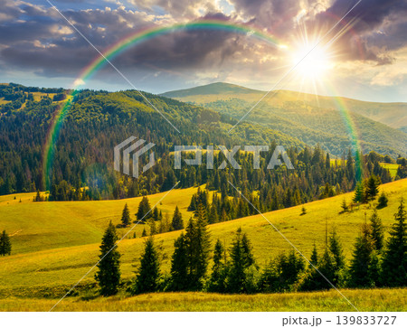 sunset over mountainous countryside landscape in summer. view of green rural scenery with grassy pastures and rolling forested hills. wonderful mountain weather with cloudy sky. weather with rainbow sunset over mountainous countryside landscape in summer. view of green rural scenery with grassy pastures and rolling forested hills. wonderful mountain weather with cloudy sky. weather with rainbow 139833727