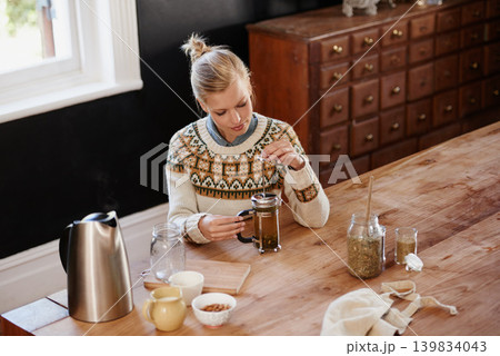 Woman, herbal tea and prepare with leaves at kitchen table with french press or kettle for health, beverage or detox. Female person, plunger and relax morning for breakfast drink, vacation or home Woman, herbal tea and prepare with leaves at kitchen table with french press or kettle for health, beverage or detox. Female person, plunger and relax morning for breakfast drink, vacation or home 139834043