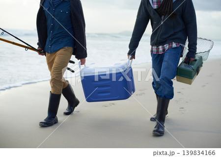 Fishing, walking and men with cooler on beach together with tackle box, water and holiday. Ocean, fisherman and feet of friends with rods, bait and tools at waves on winter morning vacation at sea. Fishing, walking and men with cooler on beach together with tackle box, water and holiday. Ocean, fisherman and feet of friends with rods, bait and tools at waves on winter morning vacation at sea. 139834166