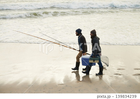 Calm, fishing and men walking on beach together with cooler, tackle box and holiday conversation. Ocean, fisherman and friends with rods, bait and tools at waves on winter morning vacation at sea. Calm, fishing and men walking on beach together with cooler, tackle box and holiday conversation. Ocean, fisherman and friends with rods, bait and tools at waves on winter morning vacation at sea. 139834239