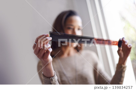 Woman, photographer and film negative for creative prints at window for sun or retro images for job, inspiration or hobby. Female person, artistic and roll for picture development, photoshoot or job Woman, photographer and film negative for creative prints at window for sun or retro images for job, inspiration or hobby. Female person, artistic and roll for picture development, photoshoot or job 139834257
