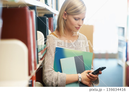 Woman, books in library and smartphone, education and research on university website for studying and knowledge. Student on campus, using phone for email or ebook, information and reading online Woman, books in library and smartphone, education and research on university website for studying and knowledge. Student on campus, using phone for email or ebook, information and reading online 139834416