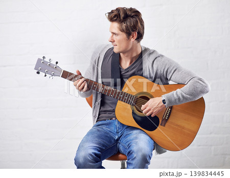 Man, guitar and musician with art and music, acoustic for entertainment and performance against wall background. Busker, artist and musical instrument for creativity, track or song with talent Man, guitar and musician with art and music, acoustic for entertainment and performance against wall background. Busker, artist and musical instrument for creativity, track or song with talent 139834445