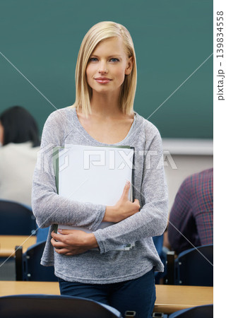 Student, classroom and portrait of woman in college for study, learning and development at campus. Female person, confident and paper for education, knowledge or academic growth at university Student, classroom and portrait of woman in college for study, learning and development at campus. Female person, confident and paper for education, knowledge or academic growth at university 139834558