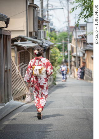 伝統的な通りを歩く赤い花柄の浴衣を着た女性の後ろ姿。京都、日本 139834630