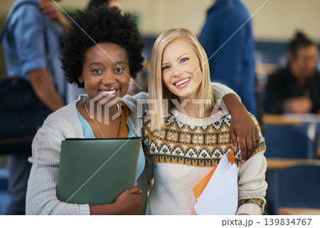 Portrait, university and women students in classroom with text books and documents for information. Smile, happy and female friends embracing, standing and bonding together in lecture hall at academy 139834767