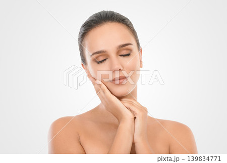 Woman, skincare and hand on face in studio for natural beauty, glow and treatment on white background. Female person, smile and cosmetics with eyes closed for healthy, skin and wellness for lifestyle Woman, skincare and hand on face in studio for natural beauty, glow and treatment on white background. Female person, smile and cosmetics with eyes closed for healthy, skin and wellness for lifestyle 139834771
