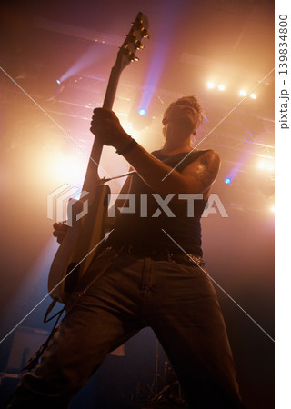 Concert, rock and guitar with man on stage for music, performance and band show. Event, spotlight and energy with male musician playing instrument at festival club for rave, disco and celebration Concert, rock and guitar with man on stage for music, performance and band show. Event, spotlight and energy with male musician playing instrument at festival club for rave, disco and celebration 139834800
