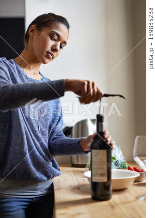 Woman, open wine and bottle for dinner, evening meal with corkscrew and preparing to drink for enjoyment and nutrition. Alcoholic beverage, tools or equipment with cooking for dining in kitchen 139835238