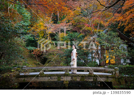 色鮮やかな紅葉の庭園の石橋に立つ着物姿の女性。京都府、日本 色鮮やかな紅葉の庭園の石橋に立つ着物姿の女性。京都府、日本 139835590