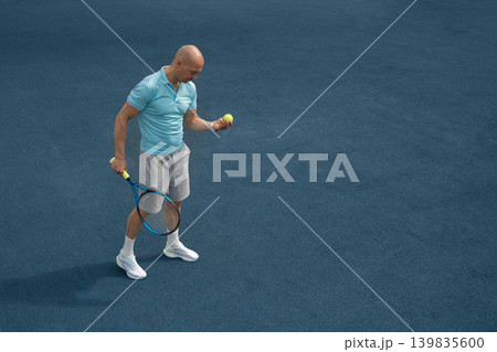 Mature tennis player standing on blue outdoor sports court 139835600