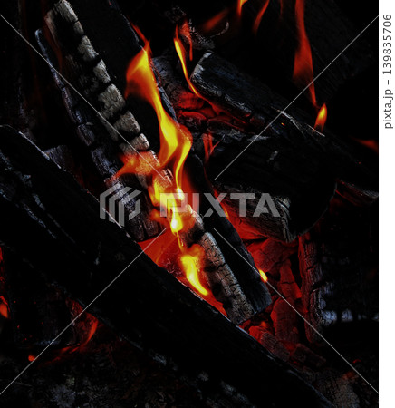 The blazing heat under black wood covered with white flakes of ash The blazing heat under black wood covered with white flakes of ash 139835706