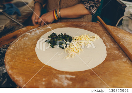 Traditional Turkish flatbread preparation with spinach and cheese filling 139835991
