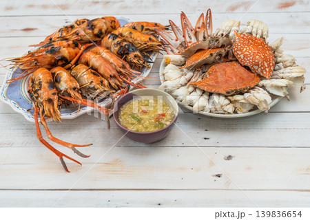 Grilled river prawns steamed crab spicy seafood sauce served on white table fresh seafood meal rich in protein coastal cuisine 139836654