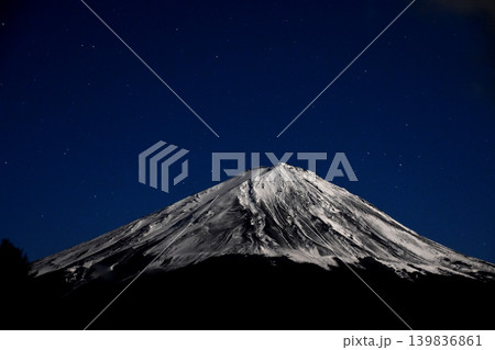 広い夜空の下で満月に照らされた厳冬のゴツゴツした雪渓が荒々しい真夜中の富士山 139836861