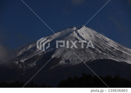 広い夜空の下で満月に照らされた厳冬のゴツゴツした雪渓が荒々しい真夜中の富士山と黒い小御岳 広い夜空の下で満月に照らされた厳冬のゴツゴツした雪渓が荒々しい真夜中の富士山と黒い小御岳 139836863