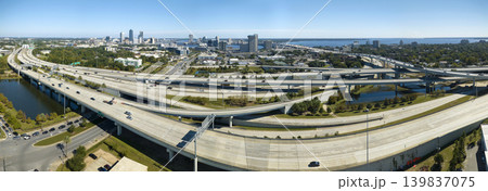Aerial view of Jacksonville city with high office buildings and american freeway intersection with fast driving cars and trucks. View from above of USA transportation infrastructure Aerial view of Jacksonville city with high office buildings and american freeway intersection with fast driving cars and trucks. View from above of USA transportation infrastructure 139837075