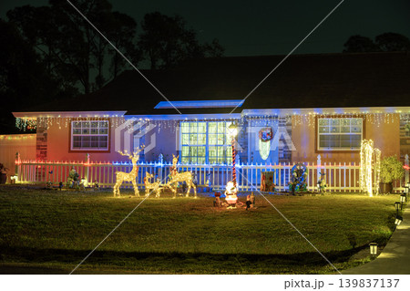 Festive yard display with glowing lights and Christmas decorations at a Florida family home. New Year holiday joy. Festive yard display with glowing lights and Christmas decorations at a Florida family home. New Year holiday joy. 139837137
