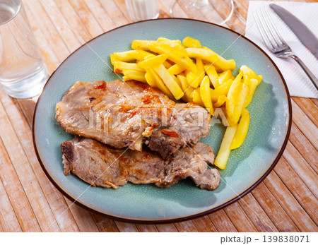 Baked pork chops on bone served with french fries Baked pork chops on bone served with french fries 139838071