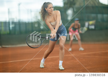 Two young women playing doubles tennis Two young women playing doubles tennis 139838316