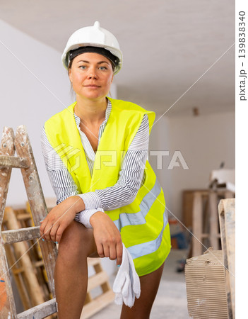 Young woman with naked legs in safety vest and construction helmet posing in apartment during overhauls 139838340