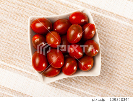 White bowl with fresh cherry kumato tomatoes on table White bowl with fresh cherry kumato tomatoes on table 139838344