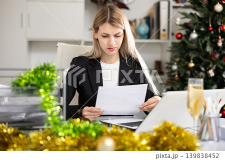 Tired business woman working with documents in business office during christmas 139838452