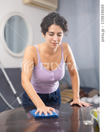 Woman with rag cleaning room at home 139838689