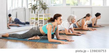Adult woman doing yoga in group in studio 139838753