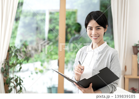 介護施設や訪問介護で明るく微笑む若い女性介護士 介護施設や訪問介護で明るく微笑む若い女性介護士 139839105