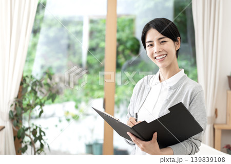 介護施設や訪問介護で明るく微笑む若い女性介護士 介護施設や訪問介護で明るく微笑む若い女性介護士 139839108