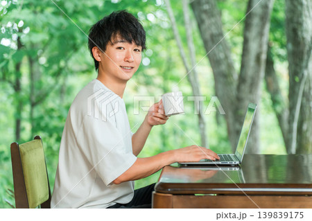 ワーケーション,リモートワークをする一息つく,休憩にコーヒーを飲むフリーランスの男性 ワーケーション,リモートワークをする一息つく,休憩にコーヒーを飲むフリーランスの男性 139839175