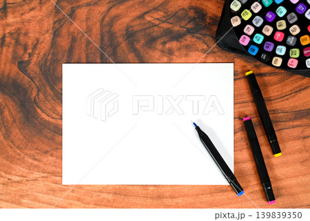 white paper for sketches and art markers on wooden surface white paper for sketches and art markers on wooden surface 139839350